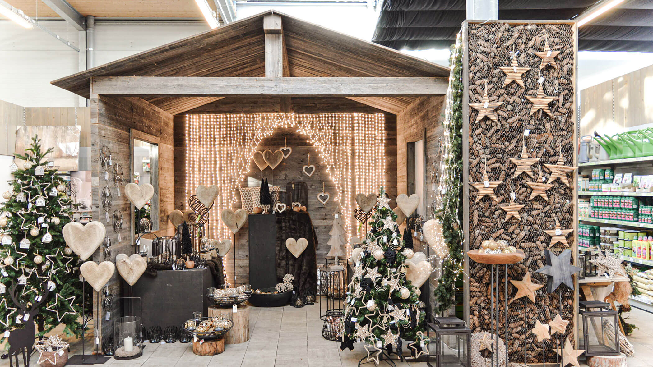 Rustikale Weihnachtsauslage mit Holzdekor, Herz- und Sternenschmuck und Weihnachtsbäumen in einer Holzhütte. - Obojes