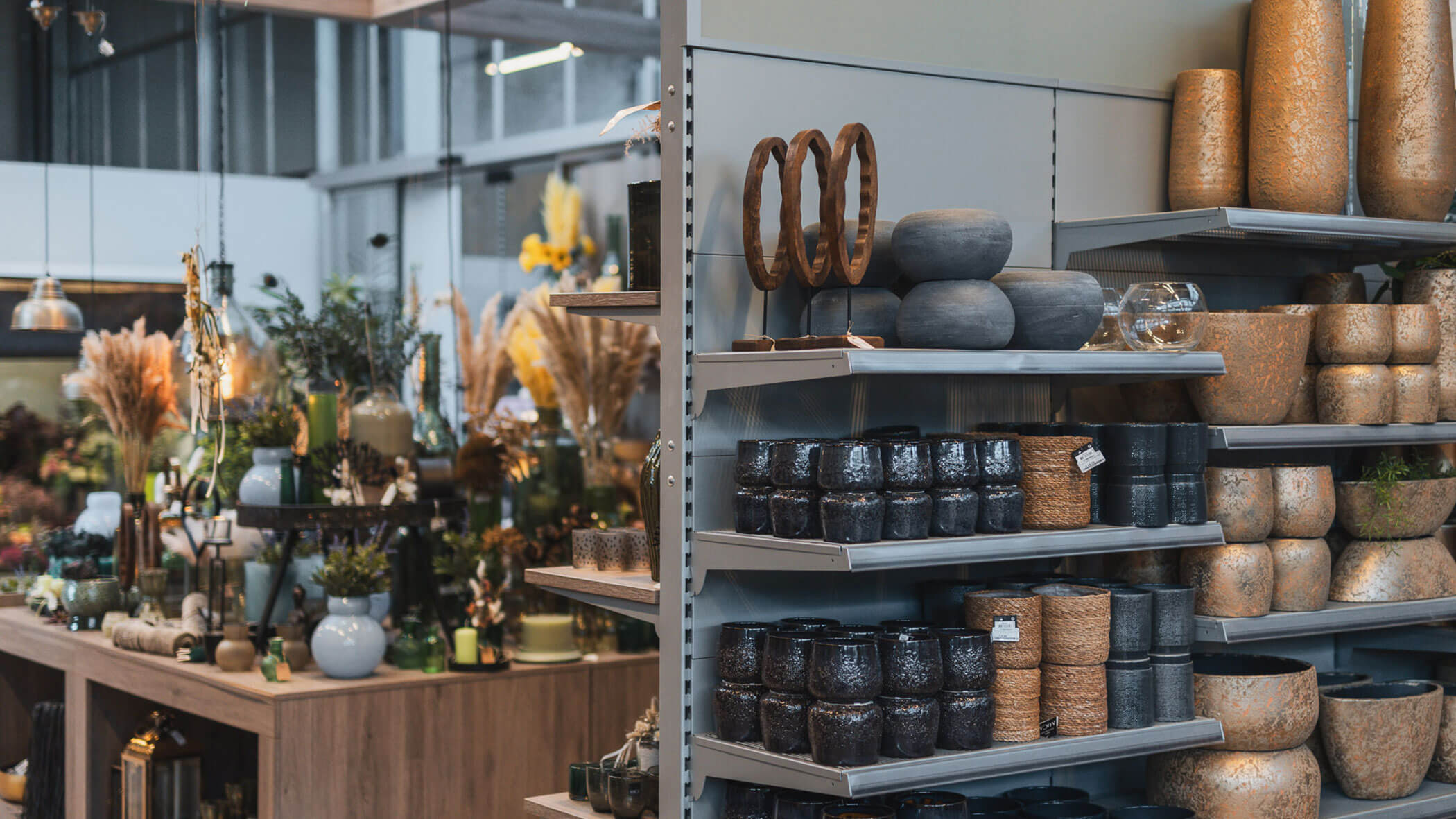 Regale mit Keramikgefäßen, Vasen und Pflanzgefäßen in einem modernen Geschäft für Pflanzen und Wohnkultur. - Obojes
