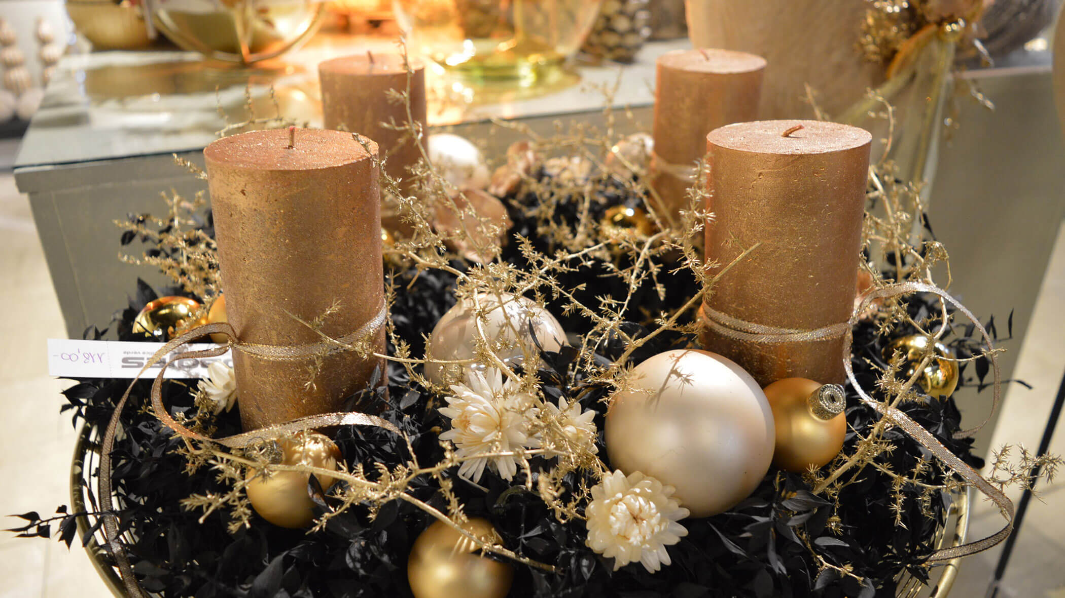 Goldene Kerzen und Ornamente mit weißen Blumen in einem festlichen Tafelaufsatz angeordnet. - Obojes